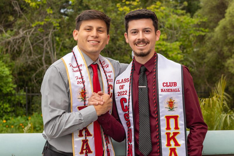 two PIKE members wearing graduation stoles