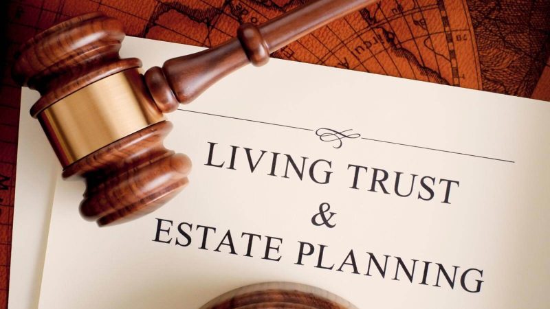 A gavel lying on a piece of paper that says Living Trust & Estate Planning