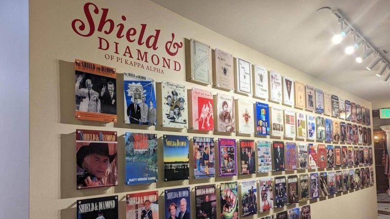 Huge display of covers of the Shield & Diamond magazine on a wall